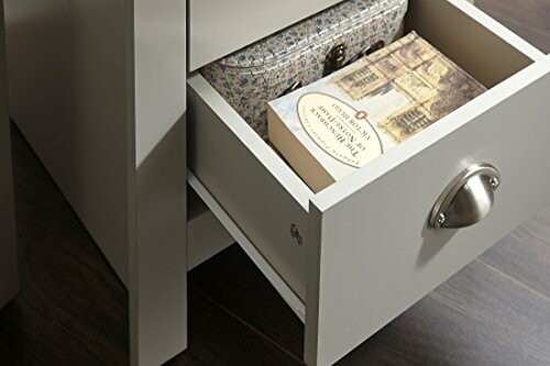 Open drawer with a book and decorative box.