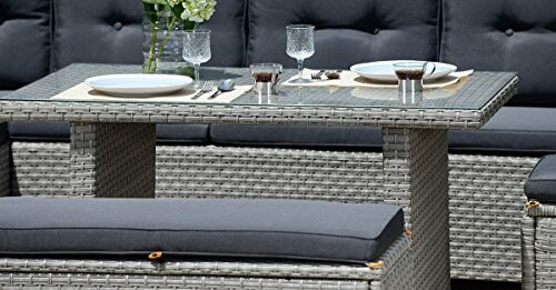 Wicker outdoor dining set with glass table and cushioned seating.